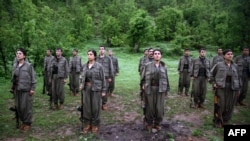 Kurdistan Workers' Party (PKK) members stand at attention after arriving in the northern Iraqi city of Dohuk on May 14.