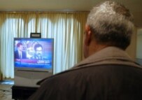 An Iraqi man watching the televised announcement of Hussein's death (AFP)