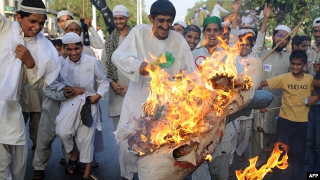 Pakistani protesters burn an effigy of Obama in Lahore in May 2010.