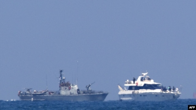 An Israeli military vessel (left) escorts one of the boats in a Gaza-bound aid convoy with Israeli troops on board to the southern Israeli port of Ashdod.