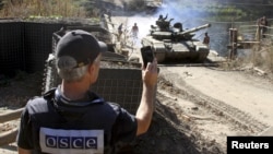 A member of the OSCE monitors the withdrawal of tanks of the Ukrainian armed forces near the village of Nyzhnje in the Luhansk region on October 5.