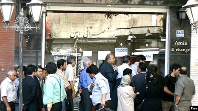 People stand in front of a currency exchange office in Tehran.