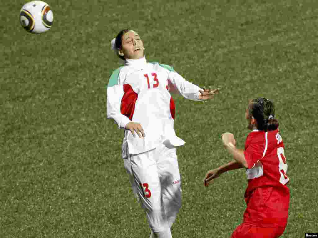 Iran's Fatemeh Shirafkannejad loses her head covering after she heads a ball during a match against Turkey at the Singapore Youth Olympic Games.
