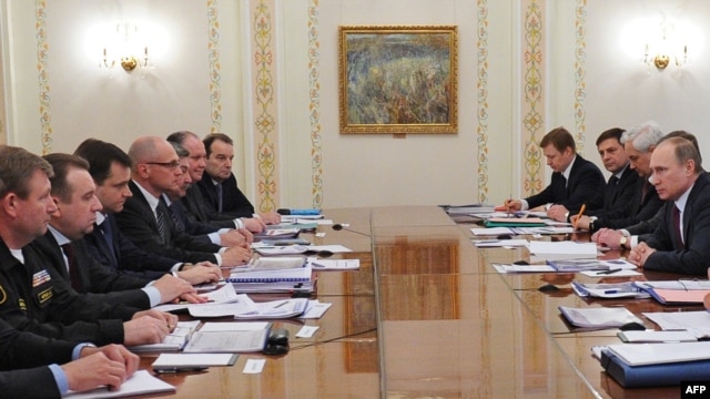 Russian President Vladimir Putin (right) speaks at a meeting with top officials on gas deliveries to Ukraine at his Novo-Ogaryovo state residence outside Moscow on April 10.