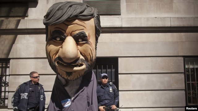 New York police officers look at a man dressed as  President Mahmud Ahmadinejad during a protest against the Iranian leader outside the Warwick Hotel in New York. 