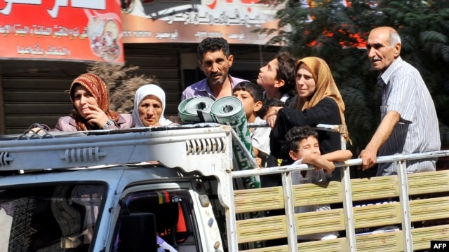 Syrian people leave the Aleppo city center after shelling by Syrian government forces.
