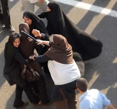 A baton-wielding policewoman (right) and protesters on 12 June