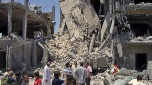 Predstavnici medija hodaju po ostacima oštećenih stambenih zgrada u Tripoliju, 19. jun 2011.