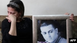 The mother of Arab-Israeli Mohammed Musallam holds a portrait of her son at their home in east Jerusalem.
