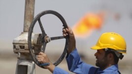 A worker adjusts a pipe at the Nassiriyah oil field, southeast of Baghdad.