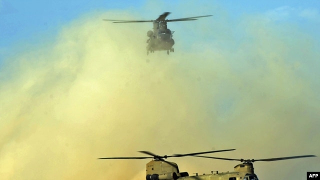 Two U.S. Chinook helicopters land at Kandahar airfield in March 2011.