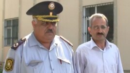 Editor Hilal Mamedov (right) of the Talysh-language independent newspaper "Tolishi Sada" is escorted by police in Baku on June 22.