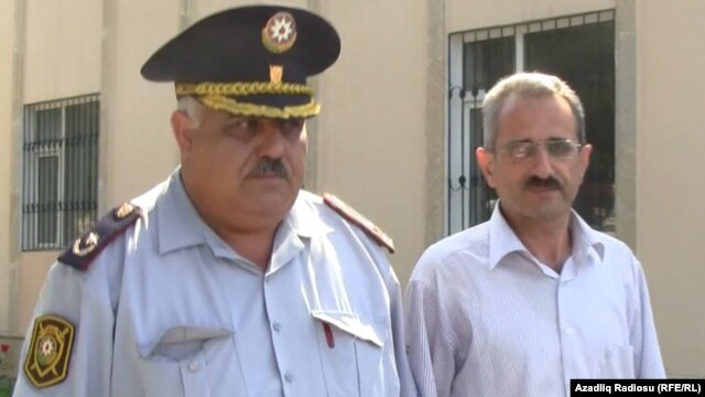 Editor Hilal Mamedov (right) of the Talysh-language independent newspaper "Tolishi Sada" is escorted by police in Baku on June 22.