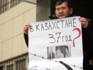 Almaty şäheriniň ýerli sudunyň oňünde oppozision aktiwistleriň tussag edilmegine protest bildirilip gurnalan pikete gatnaşyjylardan biri şygar göterip dur. Almaty, 26-njy ýanwar 2012. 