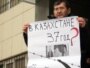 Almaty şäheriniň ýerli sudunyň oňünde oppozision aktiwistleriň tussag edilmegine protest bildirilip gurnalan pikete gatnaşyjylardan biri şygar göterip dur. Almaty, 26-njy ýanwar 2012. 
