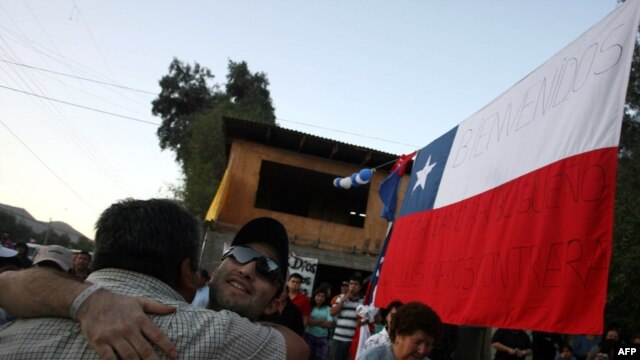 Carlos Barrios, one of the 33 rescued San Jose miners, hugs a friend on his return home in Copiapo.