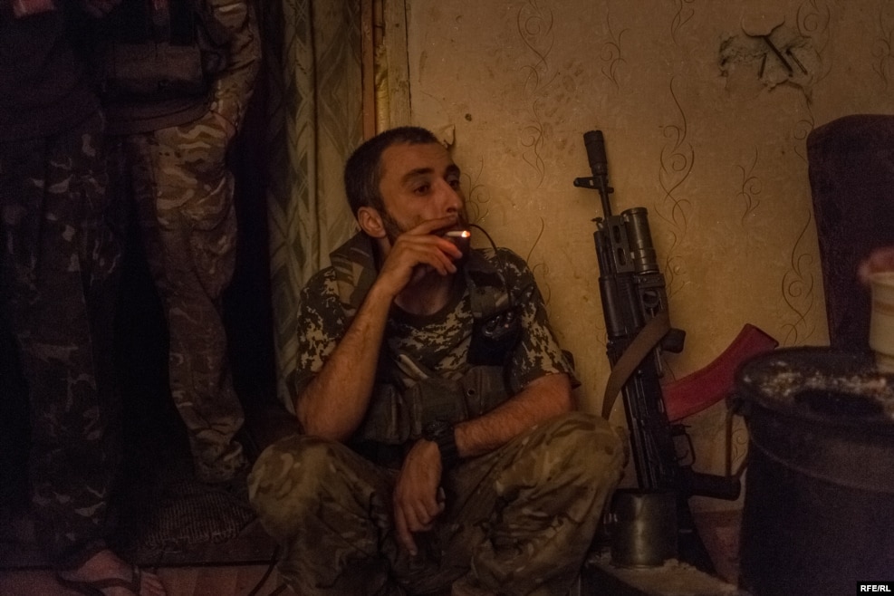 Avram pauses for a cigarette during a a firefight that has lasted for more than an hour. When he first arrived in eastern Ukraine, he was in a 12-man unit with just four rifles between them. "Some of us only had knives, some found grenades, and we just fought however we could."