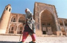 Uzbekistan - A woman walks past the Uluh-Beg Madrassah, a Koranic school in the Uzbek town of Bukhara on the old Silk Road trade route, 30Aug1995