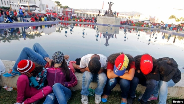 Venezuelans rest as they wait for a chance to view the body of President Hugo Chavez lying in state at the military academy in Caracas on March 8.