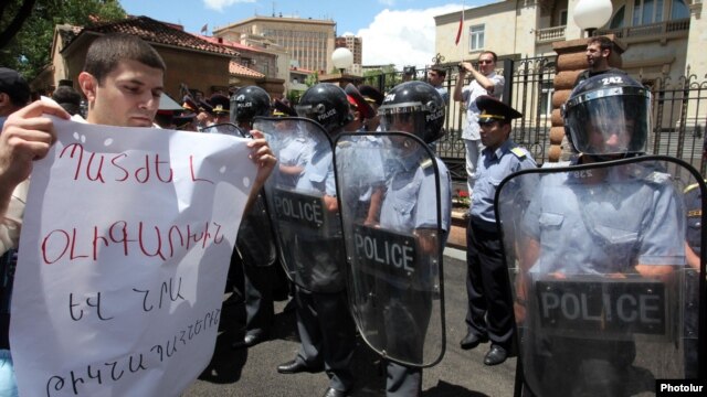 Armenia - A protester outside the presidential palace in Yerevan holds a poster demanding "punishment" for businessman Ruben Hayrapetitian and his bodyguards, 1Jul2012.