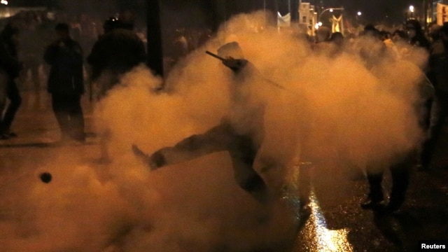 A protester kicks away a gas canister during clashes with riot police during a 48-hour strike by the two major Greek unions in central Athens on November 7.