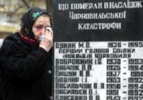 A woman mourns near a gravestone today at a ceremony in Kyiv