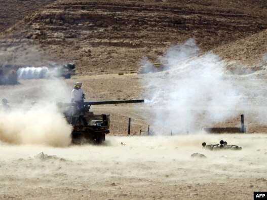 National Transitional Council fighters fire their small caliber cannon positioned on the front line near the city of Bani Walid on September 13.