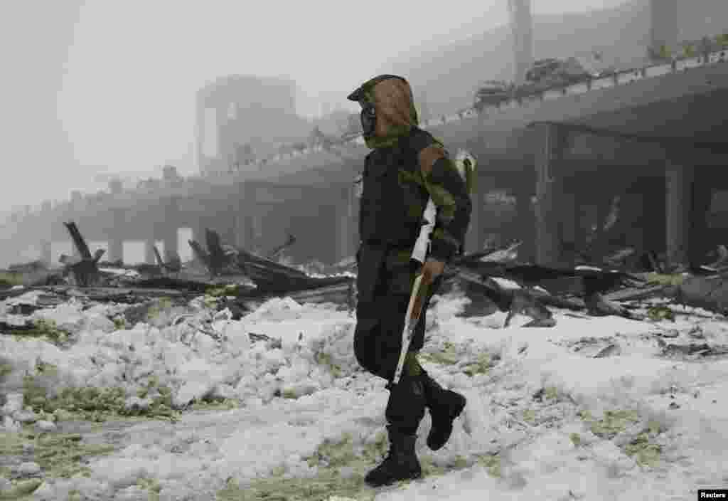 A member of the self-proclaimed "Donetsk People's Republic" forces walks near a building, destroyed during battles with the Ukrainian armed forces, at Donetsk airport. (Reuters/Aleksandr Ermochenko)