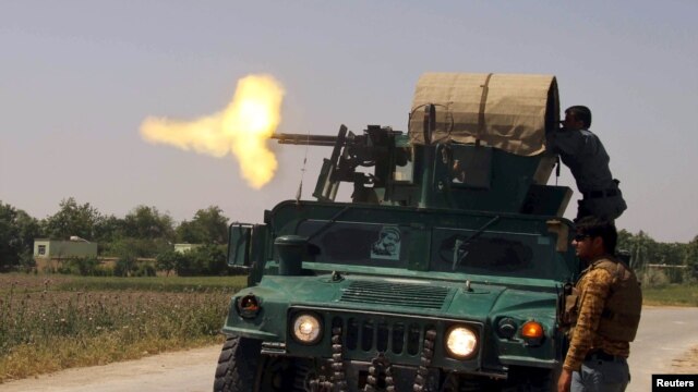 Afghan security forces fire from an armored vehicle during a battle with Taliban insurgents in Kunduz Province on May 3.