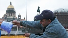 Russia -- A protester taps a fake "blue light", a blue bucket turned upside-down, to a roof of his car in St. Petersburg, 22Apr2010
