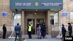 Police stand at the entrance to the Almaty Fashion Design College following the blast.