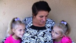Maria Barbanou (center) is raising two of her granddaughters while their mother, Maria’s daughter, is working in Italy. 