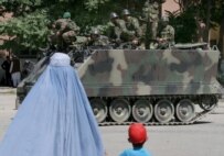 A burqa-clad woman and child watch national army soldiers in Kabul in May 2006 (epa)