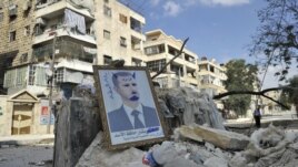 Syria -- A portrait of President Bashar al-Assad defaced to look like a devil is placed on rubble along a street during clashes with government forces in a Saif al-Dawla district of the northern city of Aleppo, 09oct2012