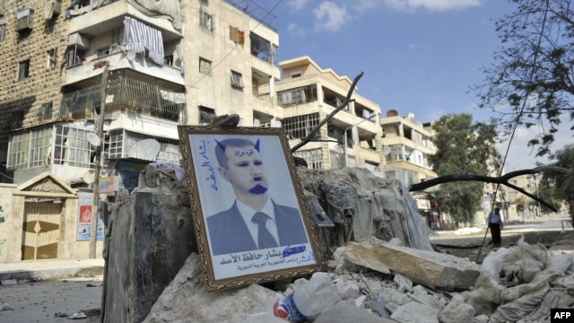 Syria -- A portrait of President Bashar al-Assad defaced to look like a devil is placed on rubble along a street during clashes with government forces in a Saif al-Dawla district of the northern city of Aleppo, 09oct2012