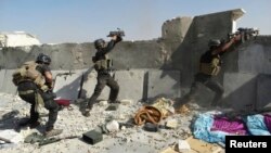 Members of the Iraqi special forces take positions during clashes with the Al-Qaeda-linked Islamic State of Iraq and the Levant (ISIL) in the city of Ramadi on June 19.