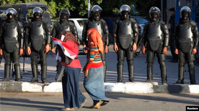 Женщины на акции против сексуального насилия в Каире перед бойцами полицейского спецназа. 2014 год