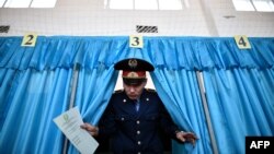 A Kazakh policeman votes during parliamentary elections in Baikonur on March 20.