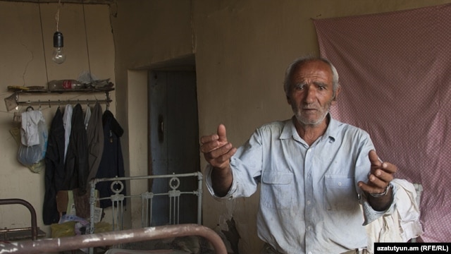 Sokrat Arakelian shows his damaged house in the village of Varhavar, which was hit by the aftershocks.