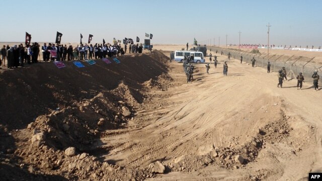 Demonstrators protest outside Camp Ashraf, home to exiled Iranian opposition members, in Iraq's western Diyala province.
