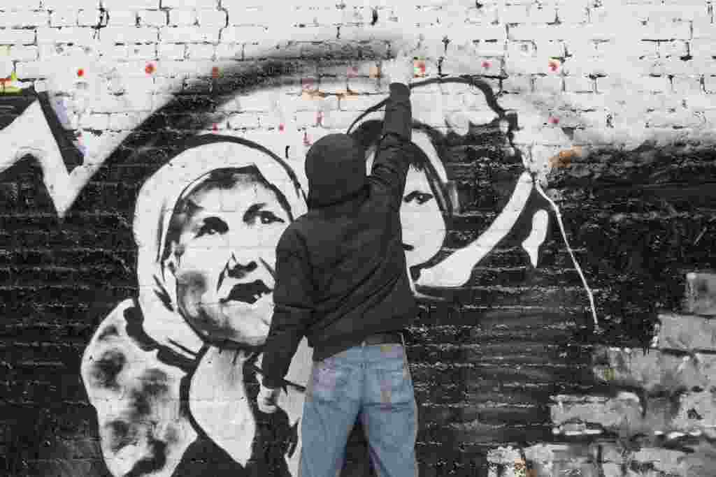 Street artist P183 paints a mural ahead of last year's Russian presidential election on a wall in central Moscow. 
