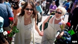 A soon-to-be-married couple works their way through the crowd outside City Hall in San Francisco in June 2008.