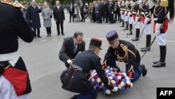 French President Francois Hollande (center left) lays a wreath in Paris as part of a ceremony to mark 70 years since victory over Nazi Germany in World War II.