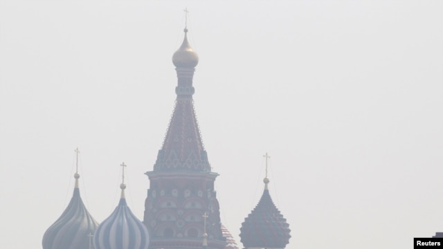 People walk along Red Square, with St. Basil's Cathedral seen through heavy smog caused by peat fires in out-of-city forests, in Moscow on July 26.