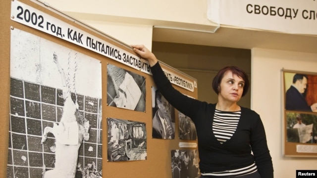 Оксана Макушина, заместитель редактора газеты "Голос республики", показывает на фотографии обезглавленной собаки, подвешенной на двери офиса редакции. Алматы, 21 ноября 2012 года.