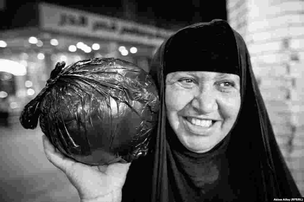 A pilgrim carries her evening shopping after visiting the tomb of Imam Ali in Najaf, one of the holiest sites for Shi'ite Muslims.