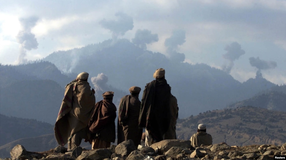 Afghan anti-Taliban fighters watch explosions from U.S. bombing in the Tora Bora Mountains in December 2001.