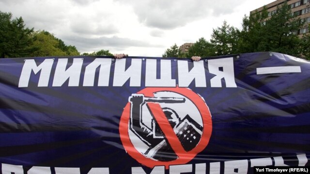 Protesters hold a banner reading "Militia [police] -- time to change" at a demonstration against police despotism.