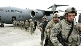 US soldiers leave a plane at Manas air field after arriving from Afghanistan
