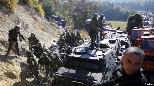 A Kosovo Serb man sits on a truck in front of Kosovo Force (KFOR) soldiers from Germany in the village of Jagnjenica near the town of Zubin Potok, near the disputed border with Serbia, in late October.